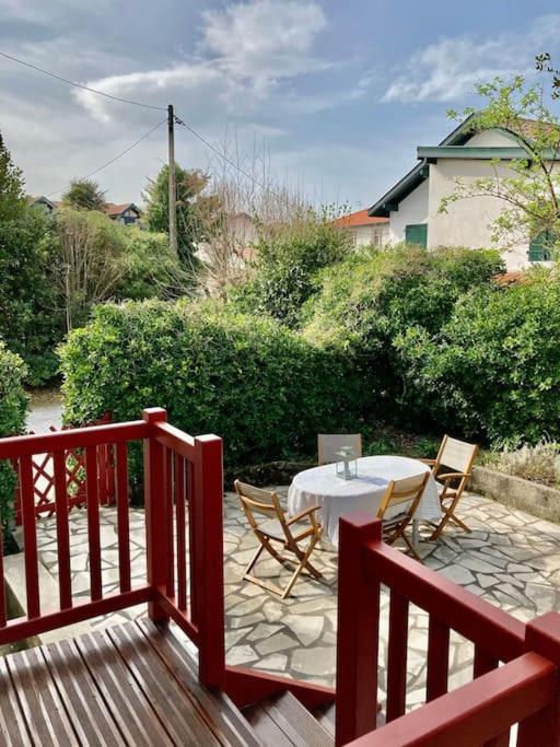 un patio avec une table et des chaises sur une terrasse dans l'établissement Garden floor apartment located next to the beach with a car park, à Biarritz