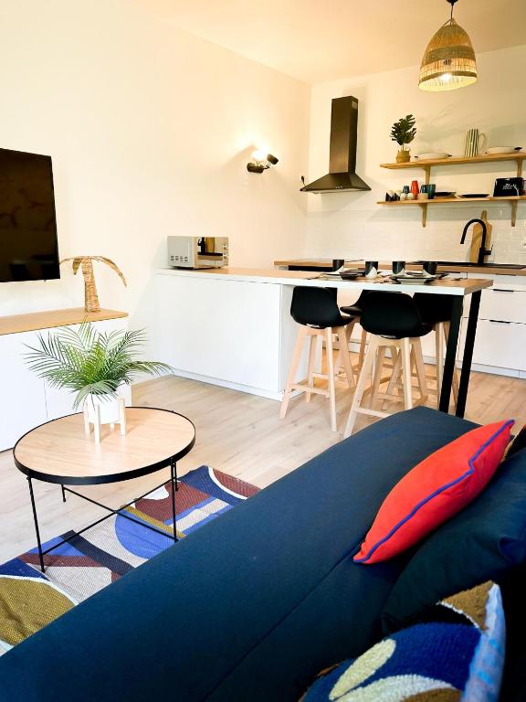 un salon avec un canapé et une cuisine dans l'établissement Appartement disneyland, à Montévrain