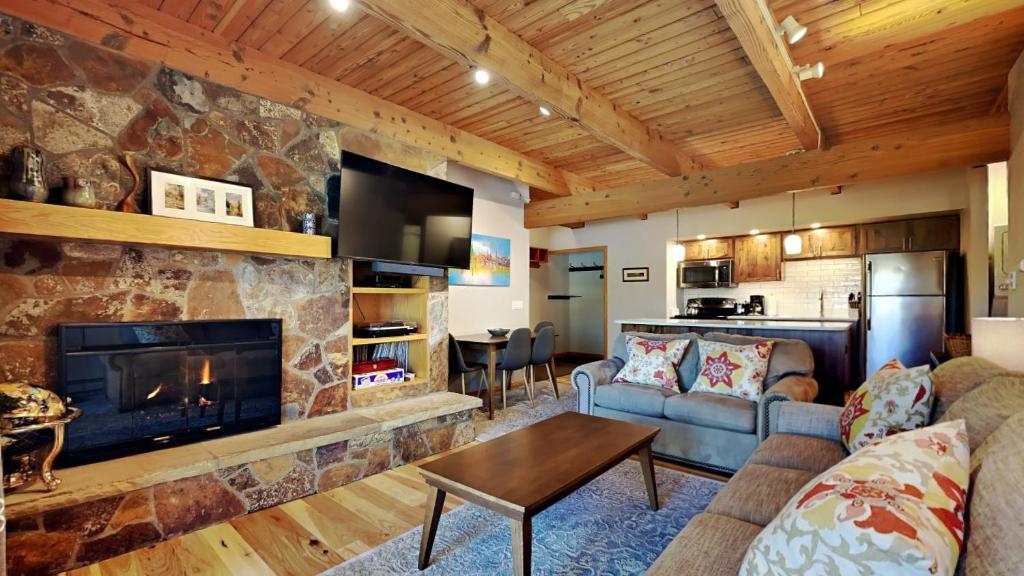 a living room with a stone fireplace and a couch at Timberline Condominiums 1 Bedroom Deluxe Unit B1C in Snowmass Village