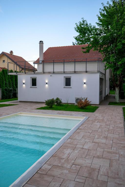 a house with a swimming pool in front of a house at One24 House in Čortanovci