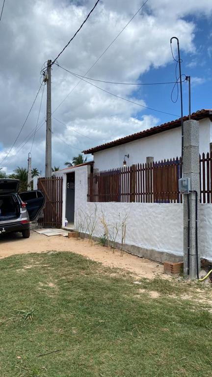 un'auto parcheggiata di fronte a una casa bianca di casa arandu a Amontada