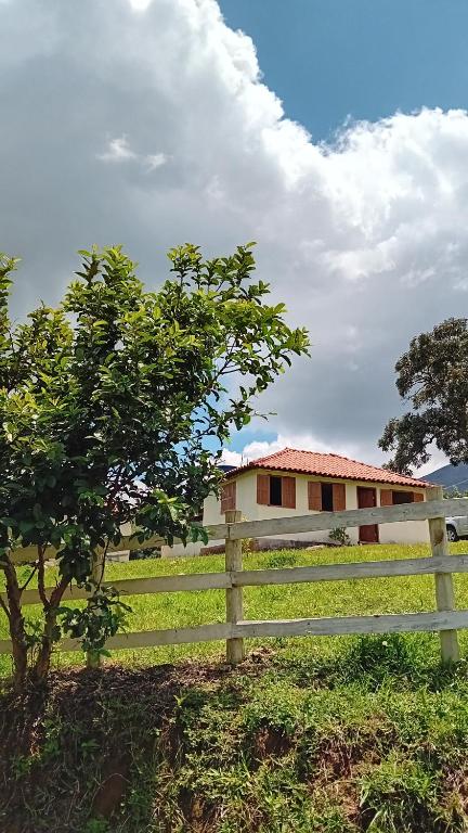 una staccionata bianca davanti a una casa di Sítio Morada do Cedro - Ibitipoca a Lima Duarte
