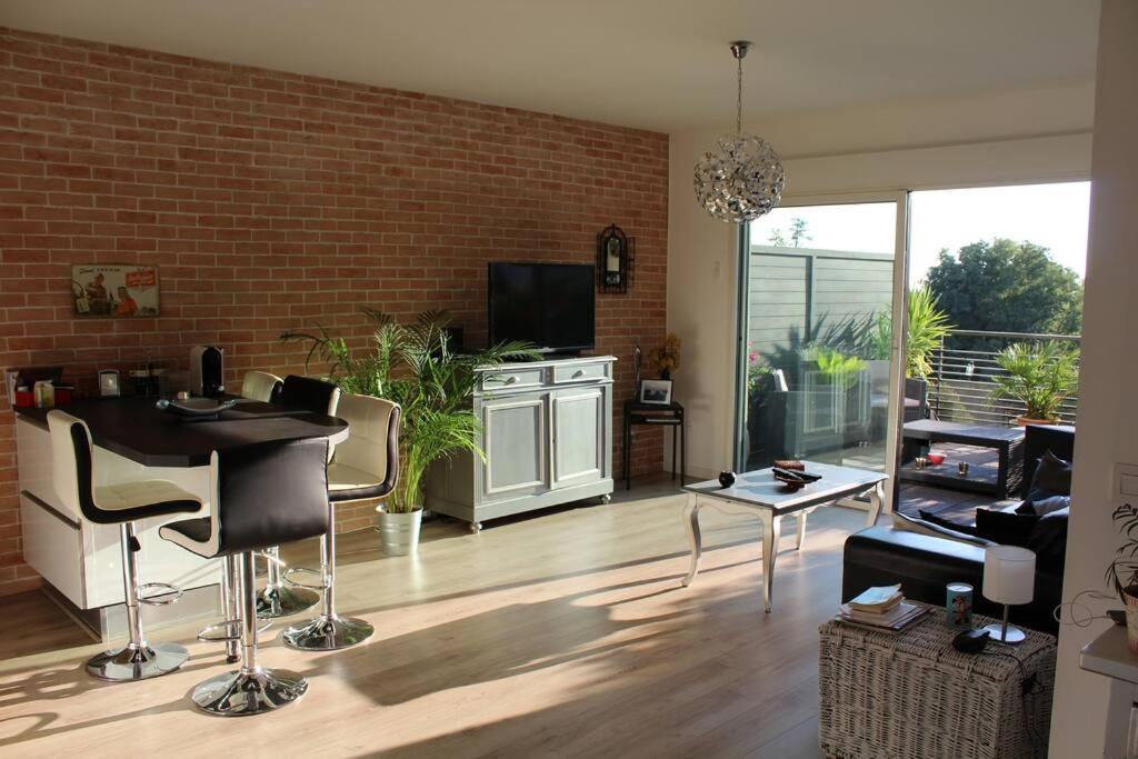 un salon avec une table et des chaises noires dans l'établissement Bel appartement 1 chambre - résidence de standing, à Aix-en-Provence