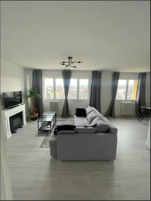 un salon avec un canapé et une télévision dans l'établissement Confort & Style au Cœur de Mulhouse, à Mulhouse