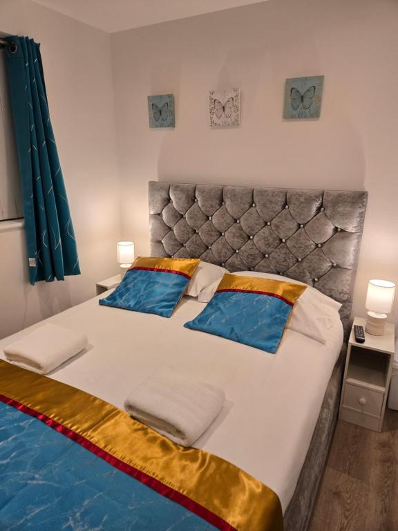 una camera da letto con un letto grande con cuscini blu di The Cosy Pod Studio - Short Stay in Salford a Manchester