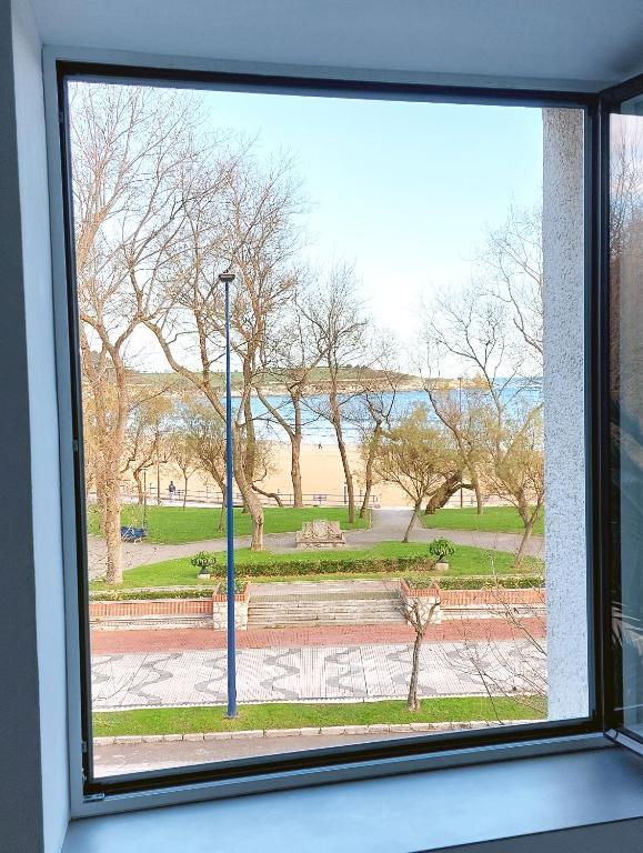 a view of a park from a window at Apartamento con vistas a la playa in Santander