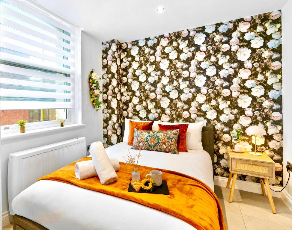a bedroom with a bed with a floral wall at GioEstate Holiday, with Free Parking, Flat28 in Brighton & Hove