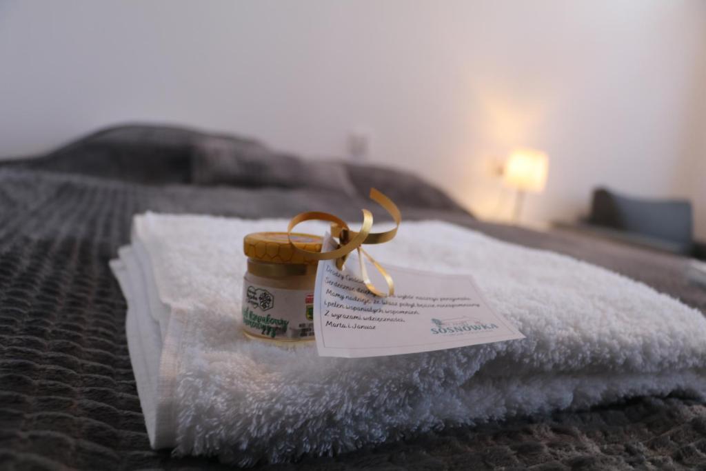 a jar of honey sitting on top of a bed at Sosnówka Pokoje Gościnne in Borne Sulinowo