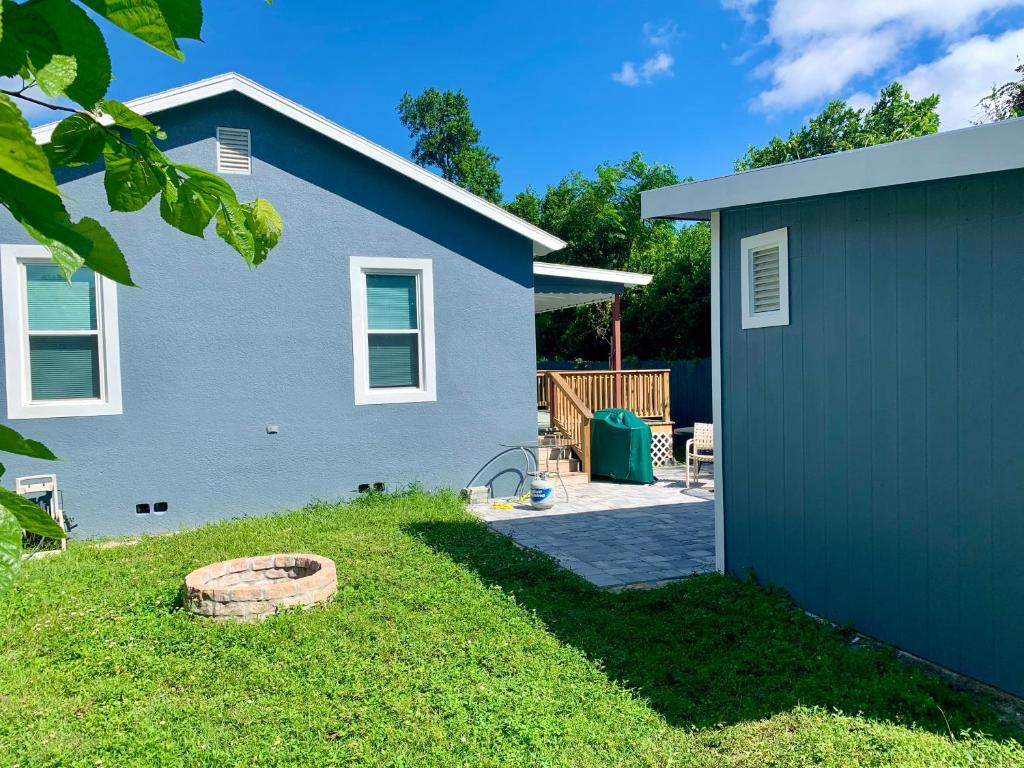 einen Hinterhof mit einem blauen Haus und einem Garten in der Unterkunft Getaway Clubhouse in Winter Haven
