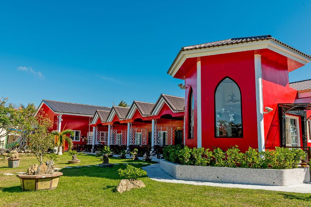 a red building with a garden in front of it at Kenting Hemingway in Kenting