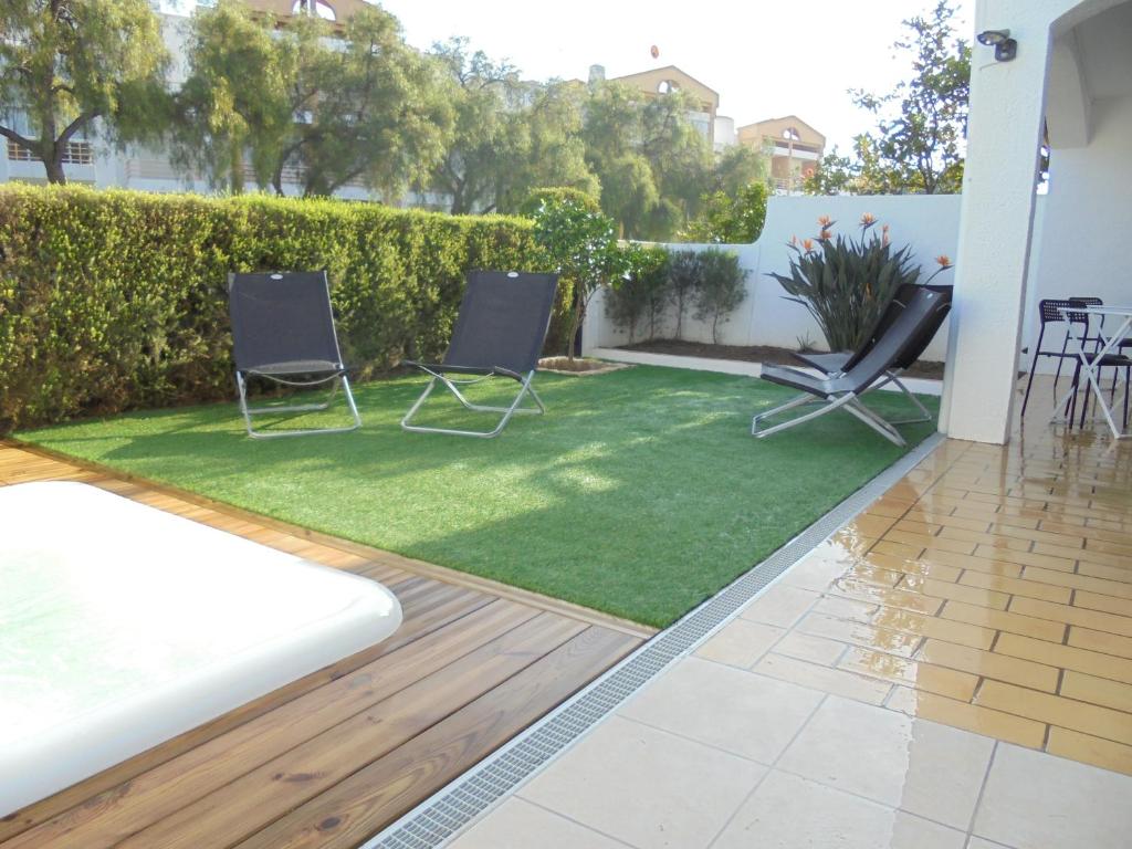 a garden with two chairs and a lawn at Lagos Charming Villas in Lagos