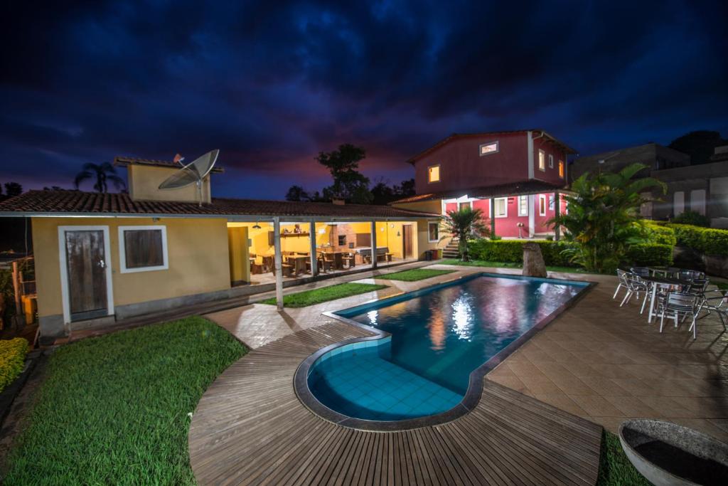 a house with a swimming pool at night at Pousada Ranchico in Brumadinho