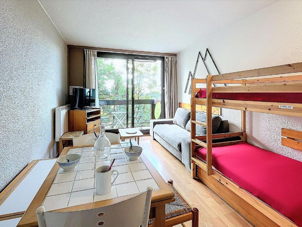 - un salon avec une table et des lits superposés dans l'établissement Studio confort au Corbier - Skis aux pieds & Balcon - FR-1-267-298, à Villarembert