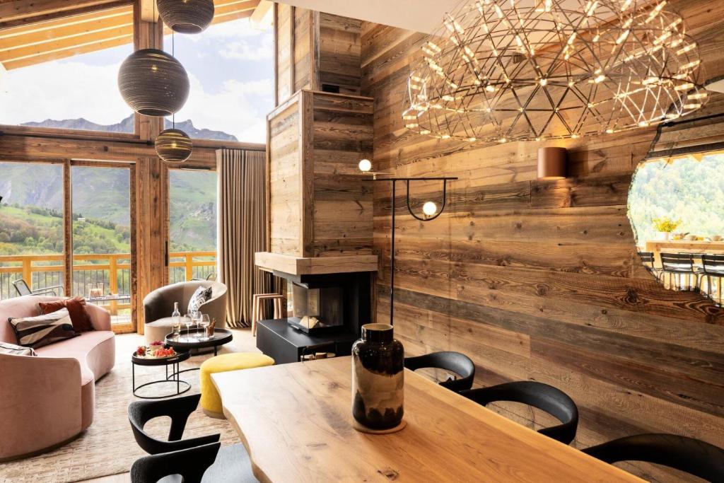 - un salon doté d'un mur en bois avec une table et des chaises dans l'établissement Résidence Caseblanche - Chalet MCFOGGIN MAE-9011, à Saint-Martin-de-Belleville