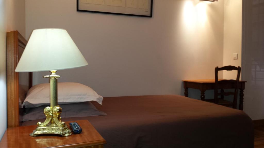 ルヴァロワ・ペレにあるRésidence Salvyのベッド横のテーブルに座るランプ