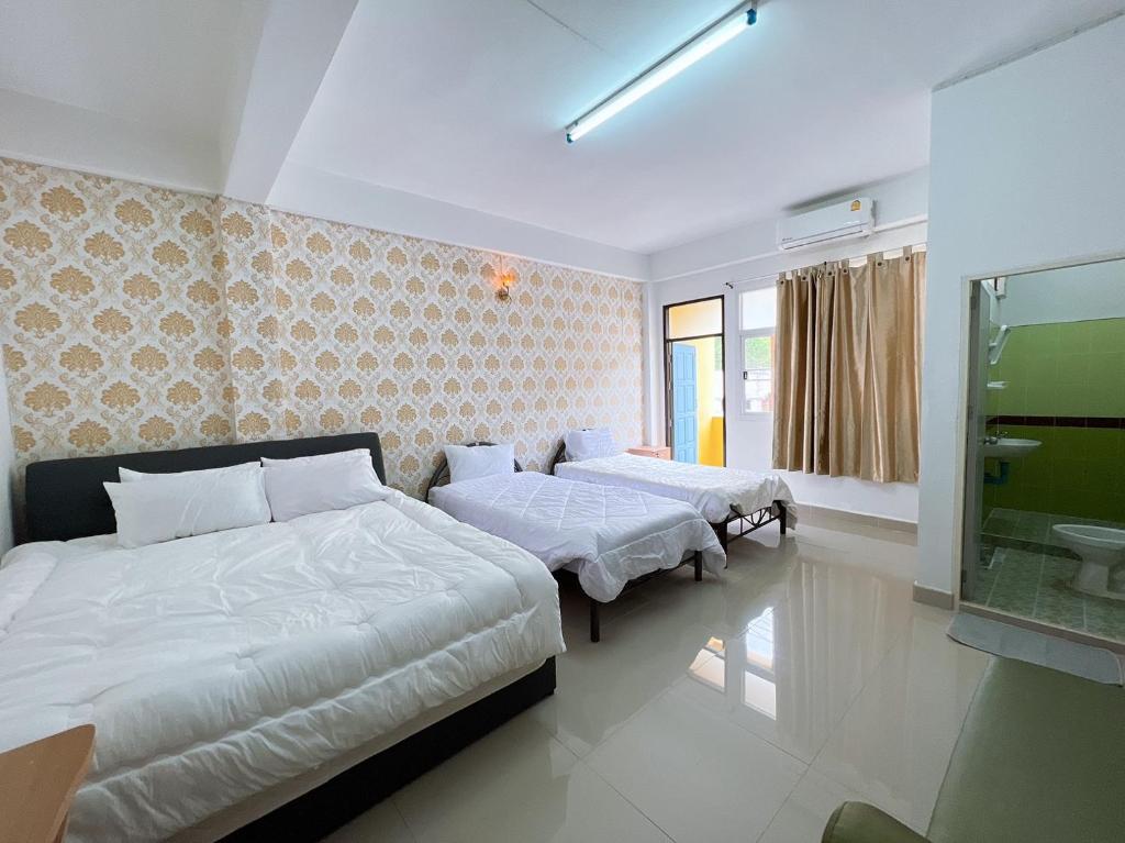 a bedroom with two beds and a window at SB Hotel in Betong