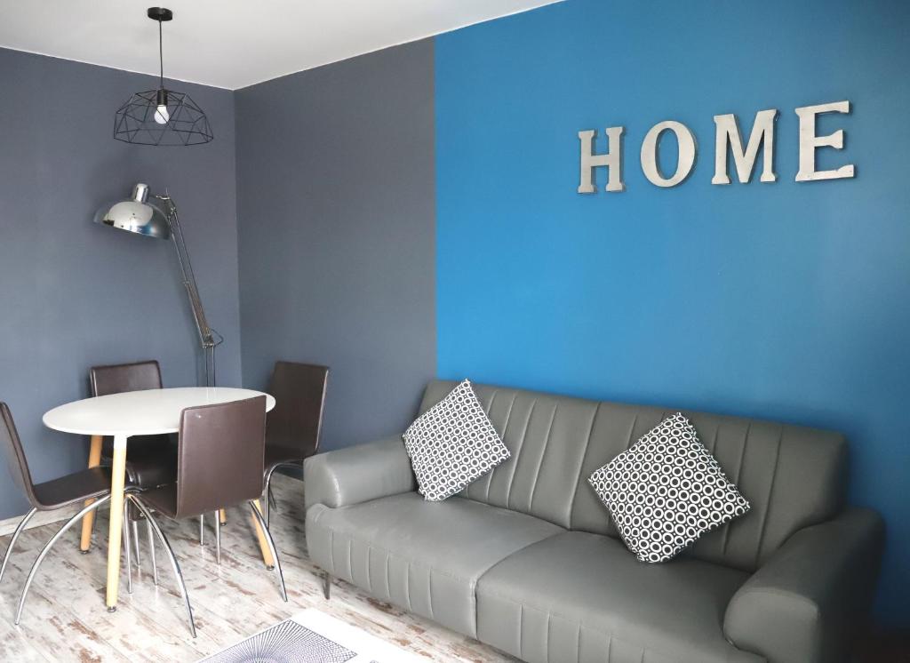 un salon avec un canapé et une table dans l'établissement Les Gîtes du Monde , Appartements 2 chambres- 4 lits simples modulables en lits doubles, au Havre