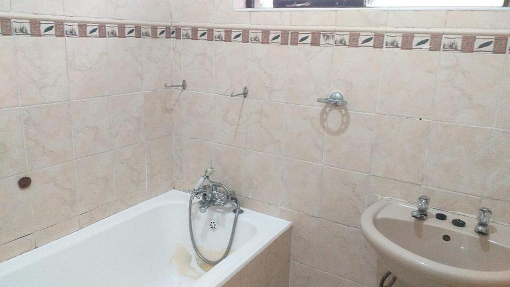 a bathroom with a tub and a sink at Lubo house in Pinetown