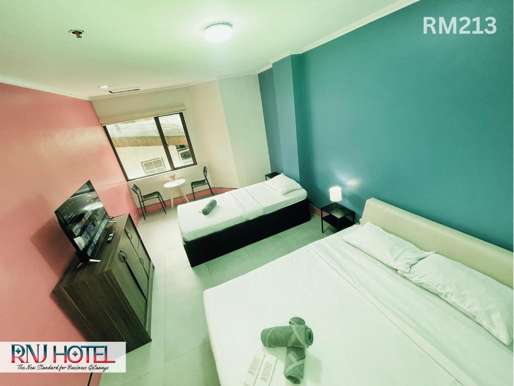 Postel nebo postele na pokoji v ubytování RNJ Hotel