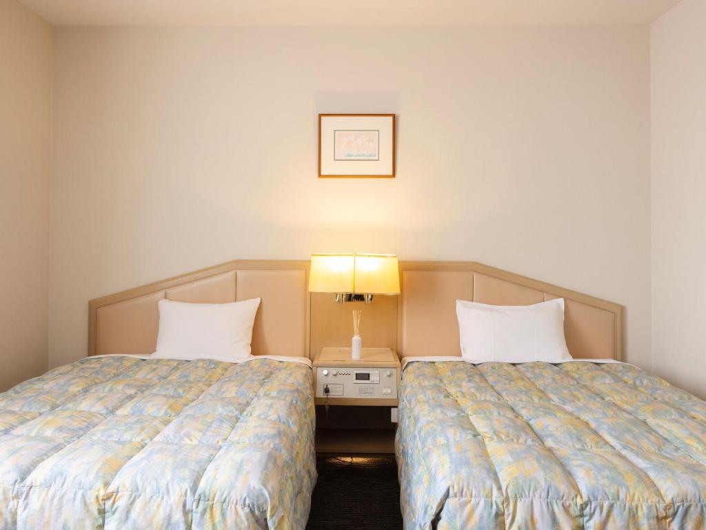Postel nebo postele na pokoji v ubytování Tsubamesanjo Washington Hotel