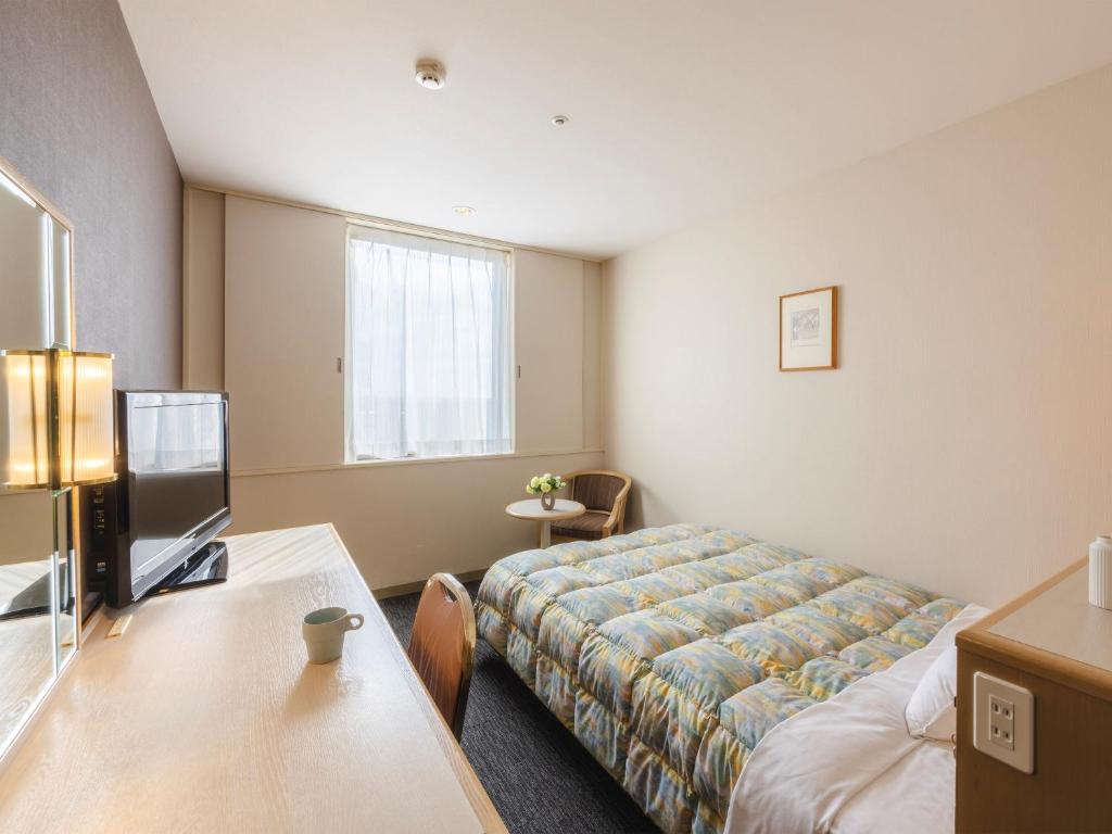 Postel nebo postele na pokoji v ubytování Tsubamesanjo Washington Hotel