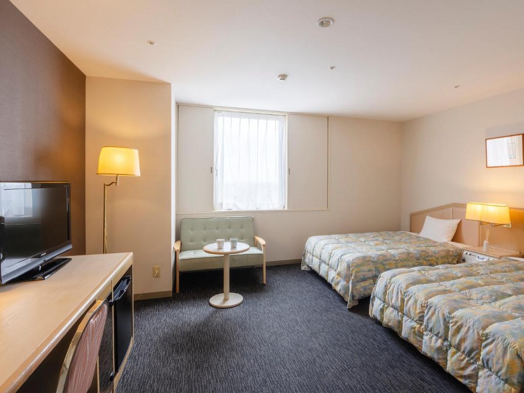 Postel nebo postele na pokoji v ubytování Tsubamesanjo Washington Hotel