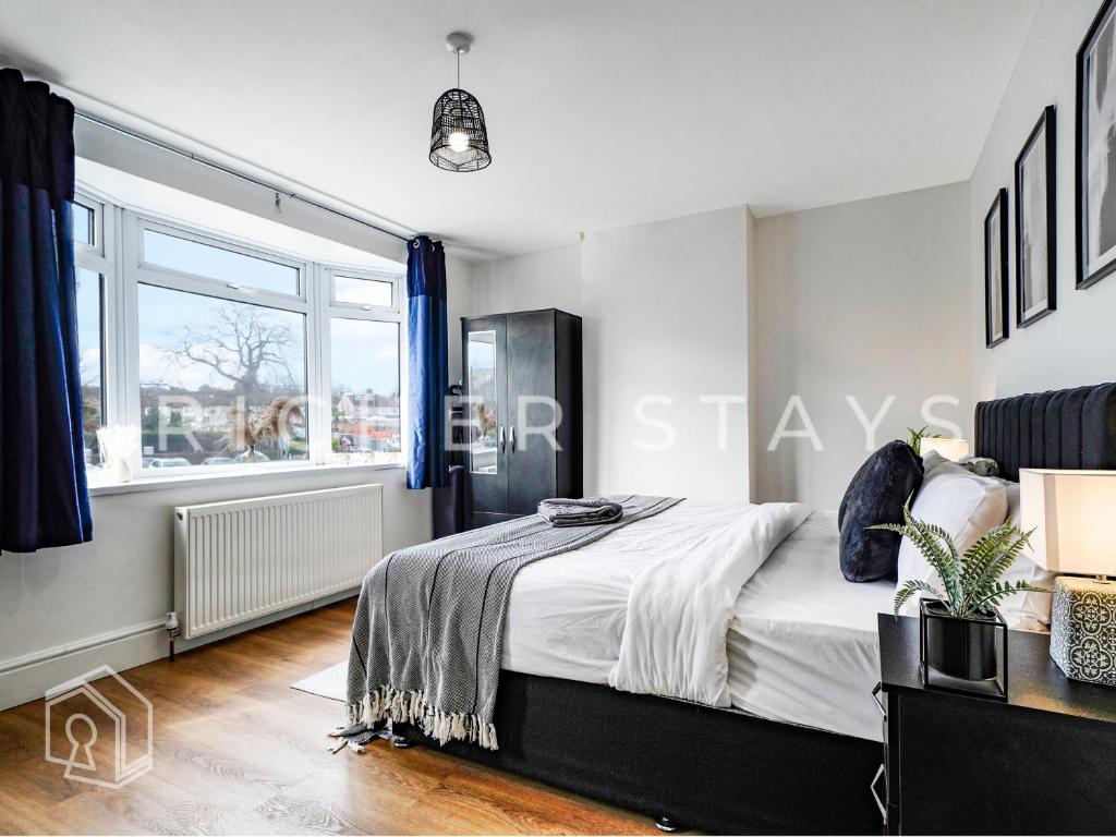a bedroom with a large bed and a window at Watford Large 5BR Home - Contractors & Families in Watford