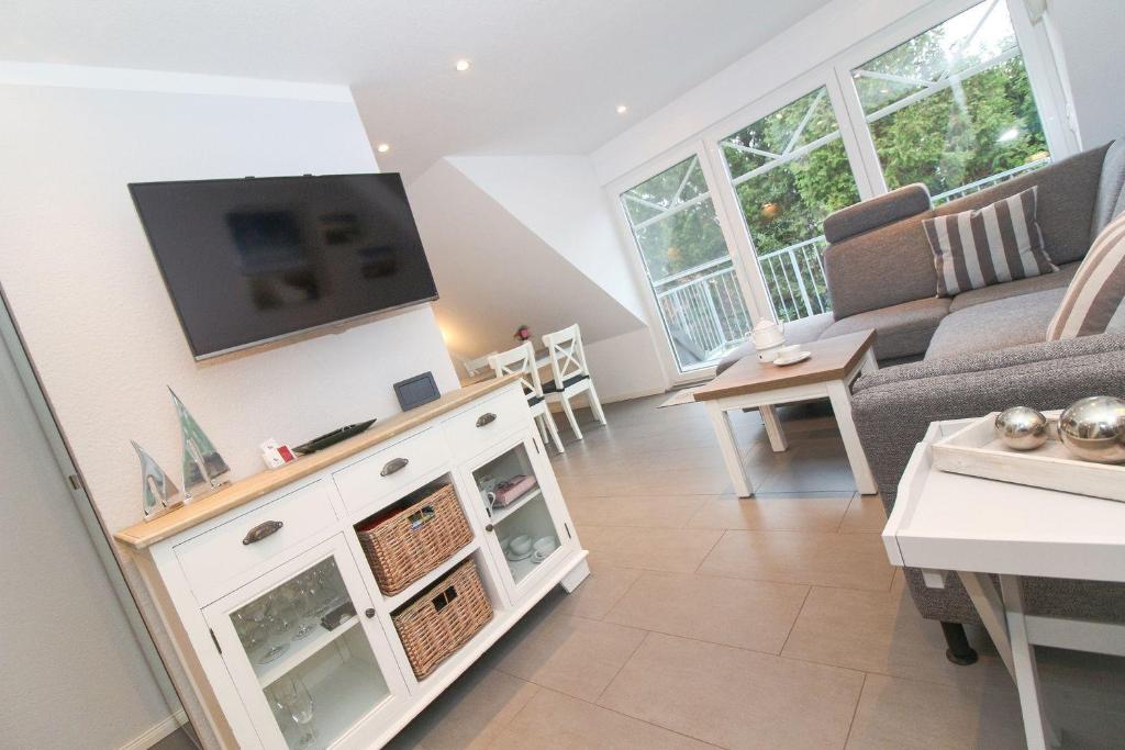 a living room with a couch and a tv at Kleine-Auszeit in Greetsiel
