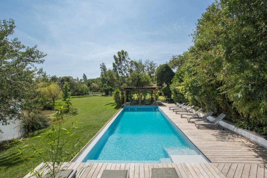 une piscine extérieure avec des chaises longues et un kiosque dans l'établissement Souvenirs Intemporels, à Arles