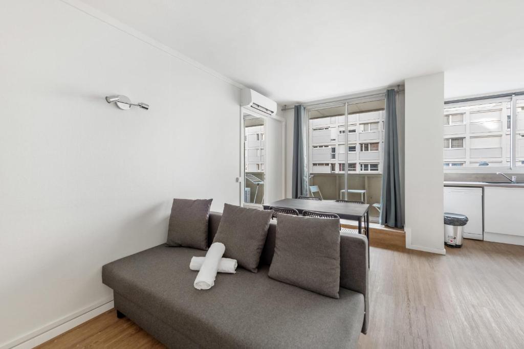 un salon avec un canapé avec un objet blanc dessus dans l'établissement Beautiful 2 bedroom apartment with balcony Villeurbanne center, à Villeurbanne
