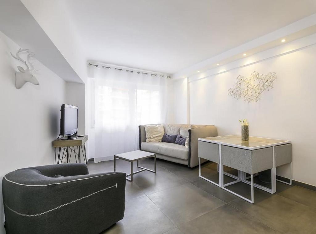 un salon avec un canapé et une télévision dans l'établissement Superbe T2 lumineux dans le centre CIO1899, à Cannes