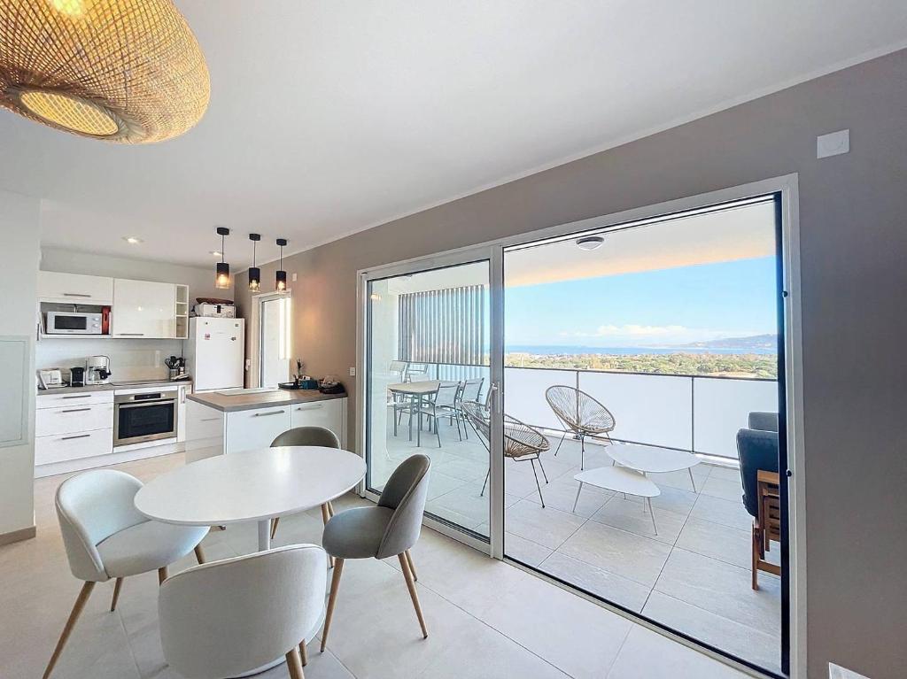 une cuisine et un salon avec une table et des chaises dans l'établissement Appartement avec vue panoramique sur la mer, à Calvi