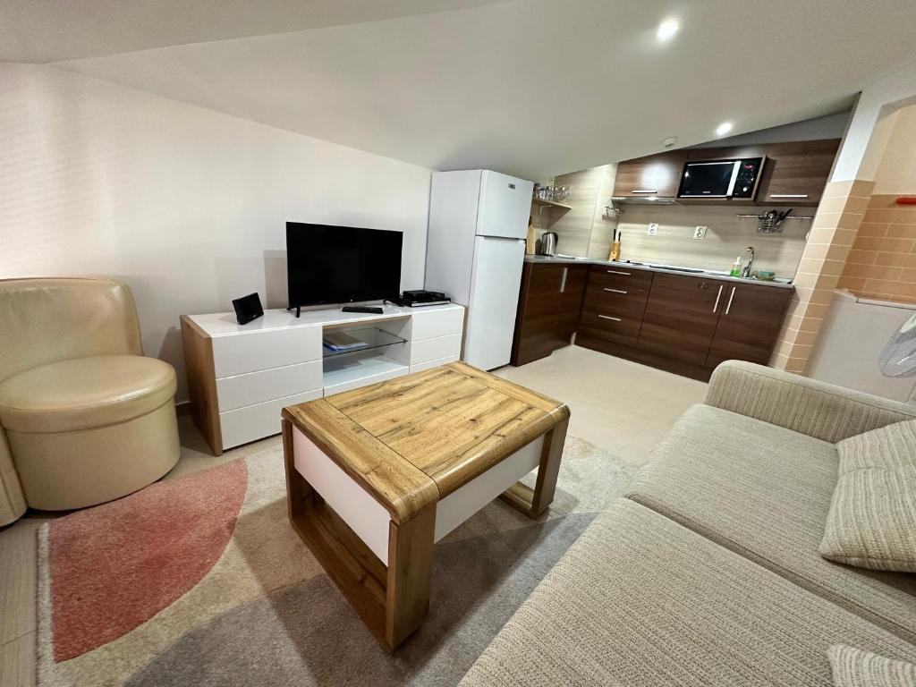 a living room with a couch and a tv and a table at Belvedere Holiday Club nice place in Bansko