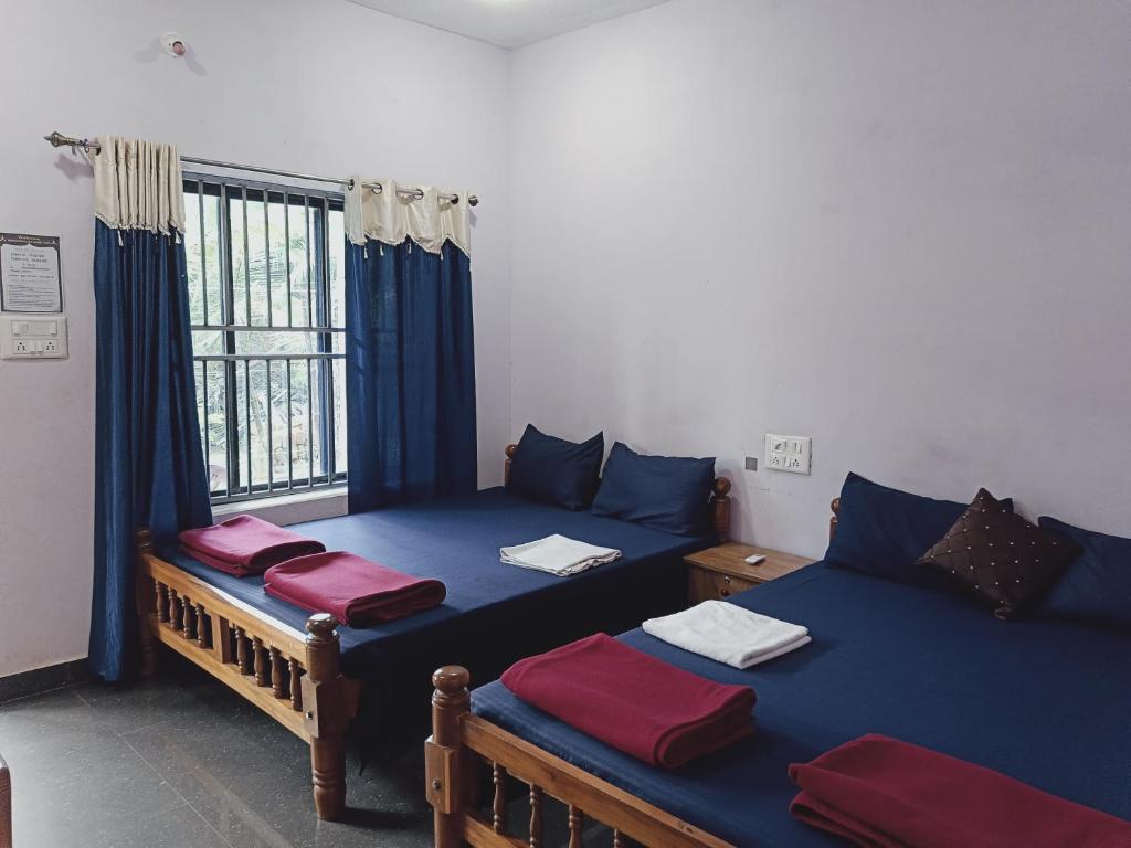 a room with two beds and a window at Parshuram Sea Shore Cafe and Rooms, Gokarna in Gokarn