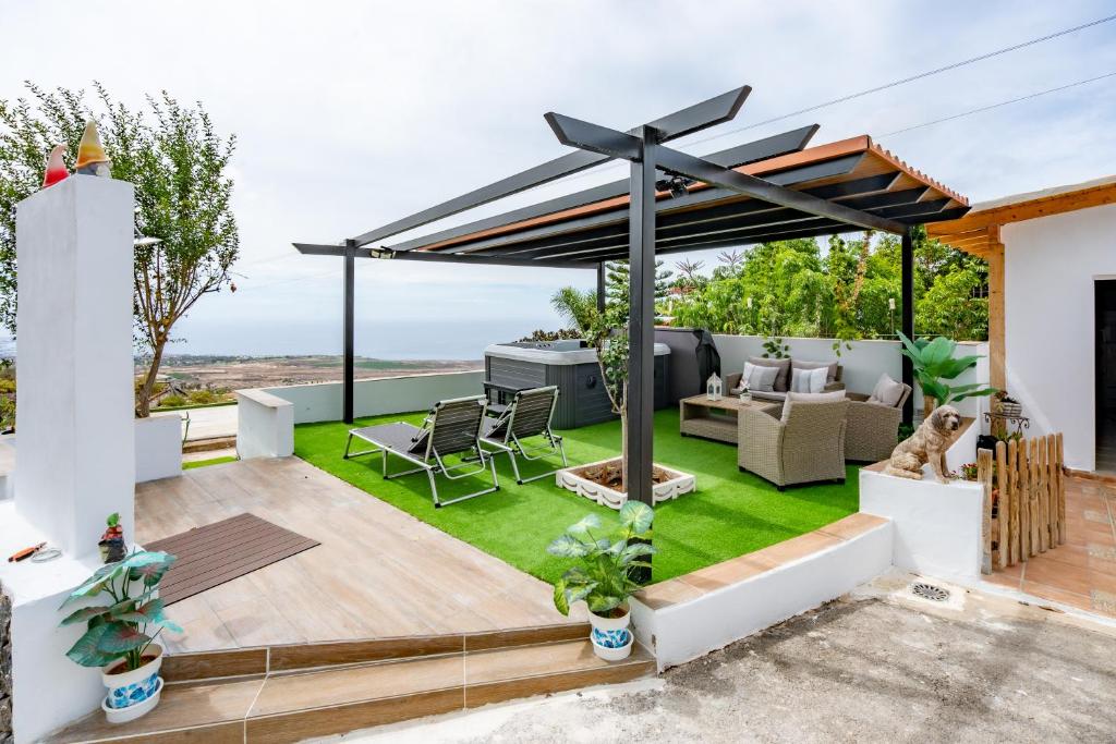 a backyard with a patio furniture and an umbrella at El rinconcito with sea view in Los Menores