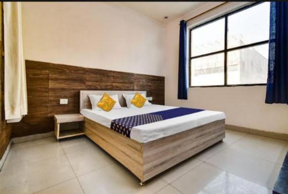 a bedroom with a large bed with a large window at Hotel CROWN PLAZA SK in Rudrapur