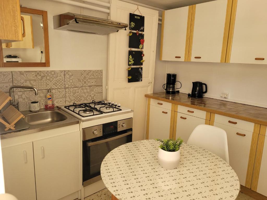 une cuisine avec une table, un évier et une cuisinière dans l'établissement Les chouchous, à Orange