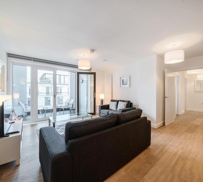 sala de estar con 2 sofás y sofá en Roomspace Serviced Apartments - Walton Court, en Hersham