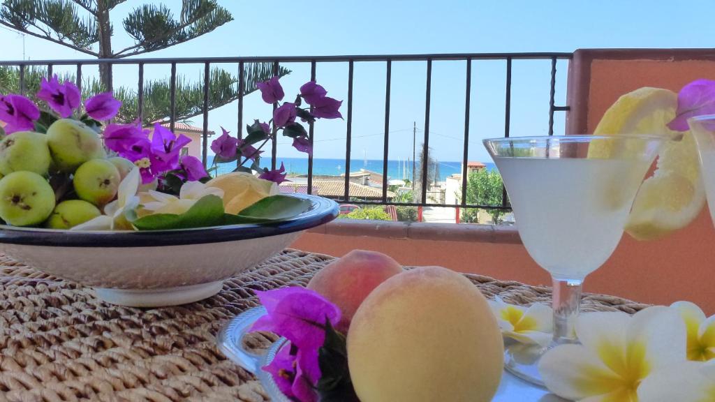 - une table avec un bol de fruits et une boisson dans l'établissement Appartamento Citreum, à Balestrate