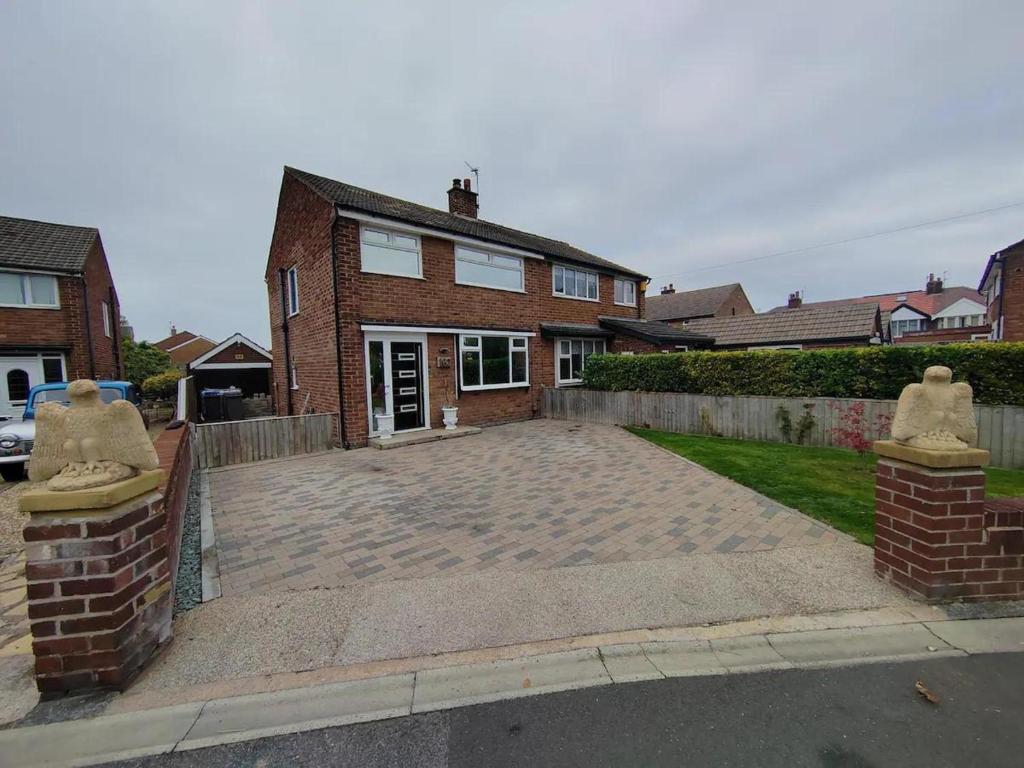 a brick house with a driveway in front of it at Cozy Blackpool Retreat with 3 Bedrooms in Blackpool