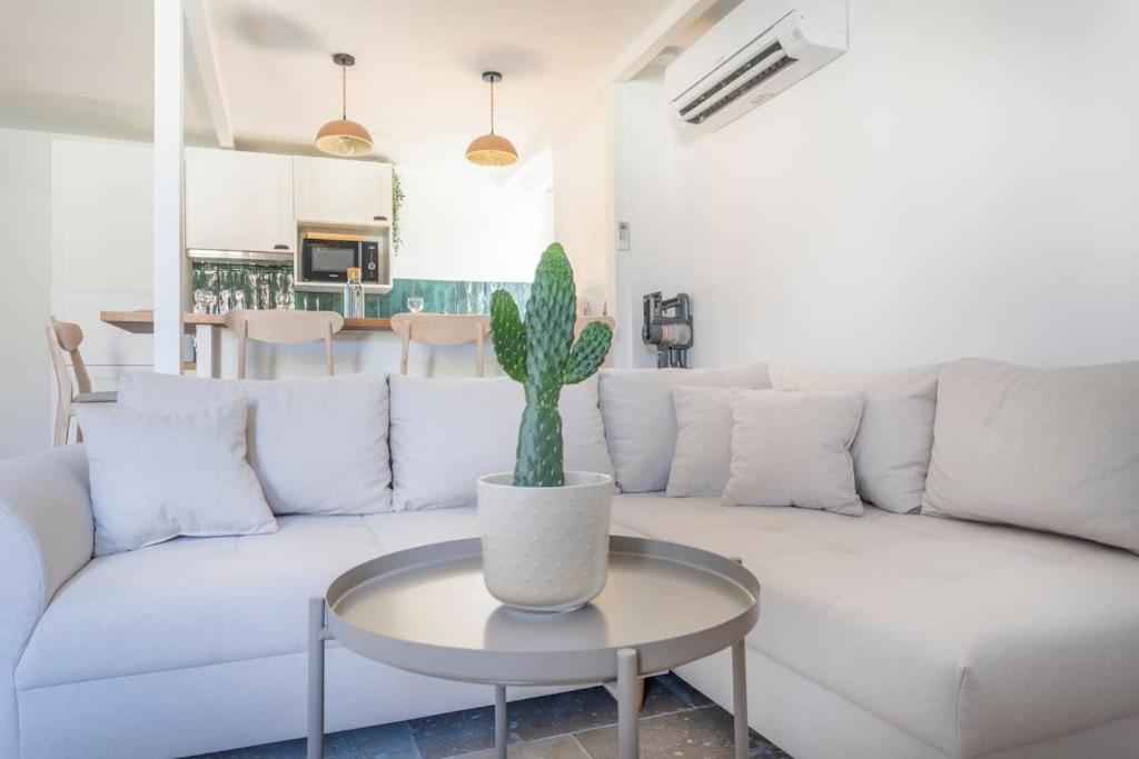 a living room with a white couch and a cactus on a table at Standing - Central - Quartier des Artistes - Les Frères de la Loc' in Marseille