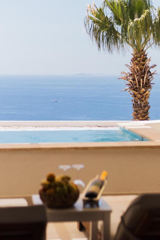 a table with a bowl of fruit next to a swimming pool at La Kumsal Hotel in Kaş