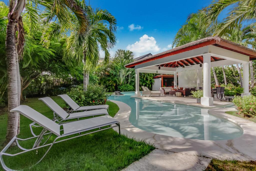 a pair of lounge chairs next to a swimming pool at Beautiful Villa with Pool, Gym & Maid in Punta Cana