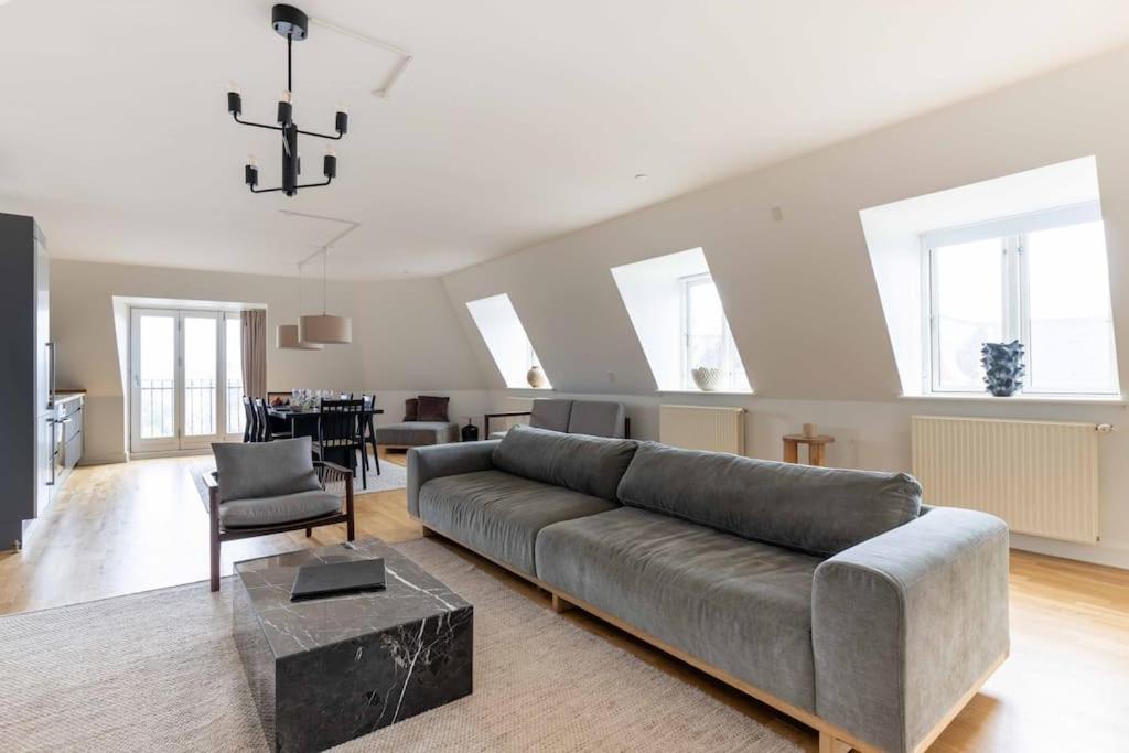 Una gran sala de estar con un sofá y una mesa. en 2BR with Amazing City Skyline View, en Copenhague