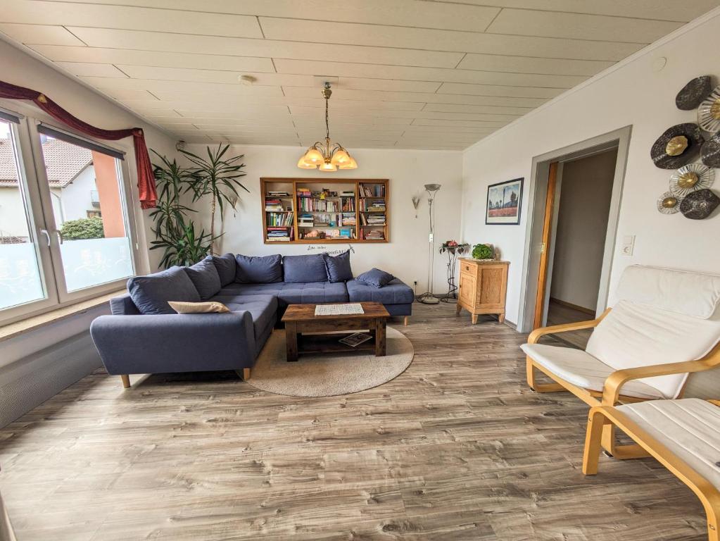 a living room with a blue couch and chairs at Ferienwohnung Friedel und Käthe in Oberthal