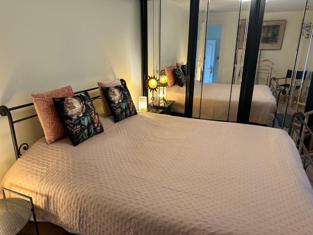 Un dormitorio con una cama con almohadas y un espejo. en Guesthouse Saint-Jean Bruges, en Brujas