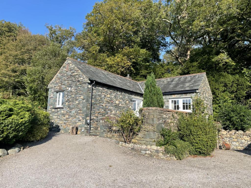 an old stone house with a stone wall at Deer Close Cottage in Keswick