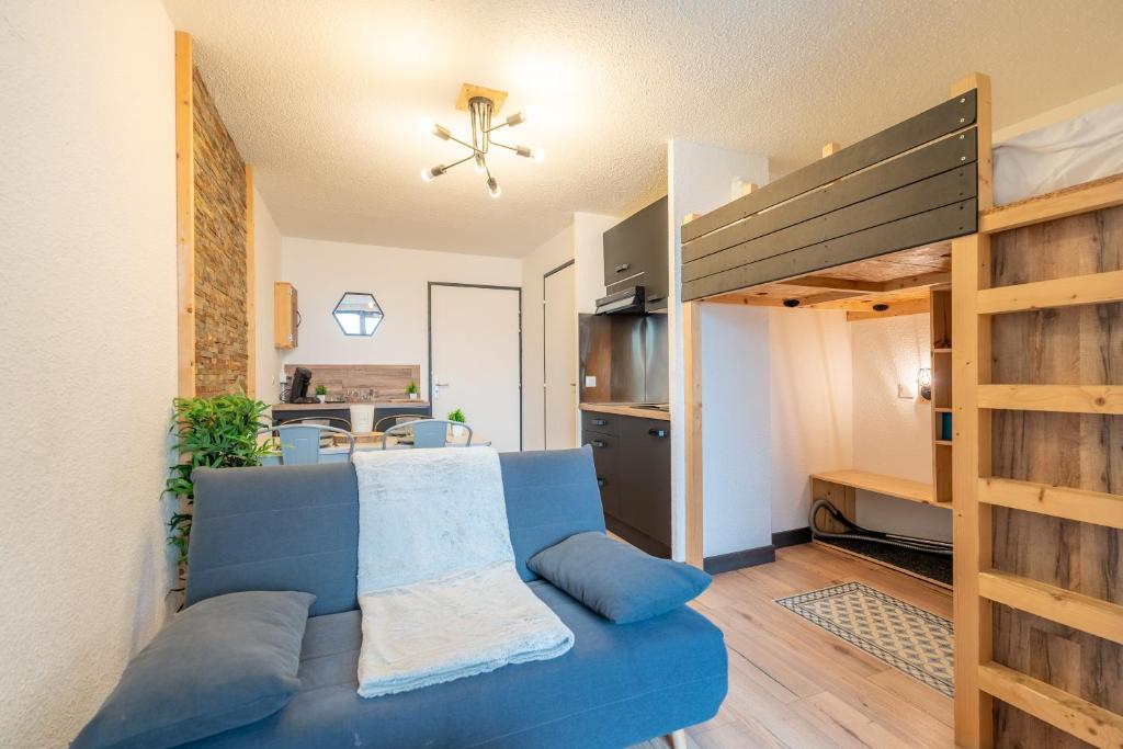 - un salon avec un canapé bleu et des lits superposés dans l'établissement Ski In-Out - Heart of Val Thorens Spacious Apartment, WiFi 1001, à Val Thorens