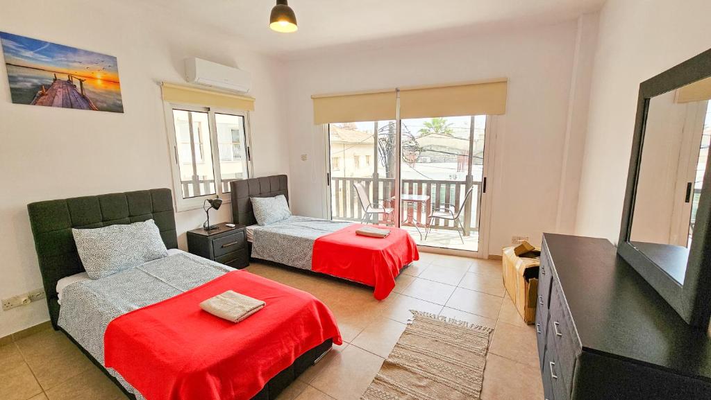 una camera da letto con due letti e una TV a schermo piatto di Sky Ward City Rooms, 150m from Chabad Lubavitch a Larnaka