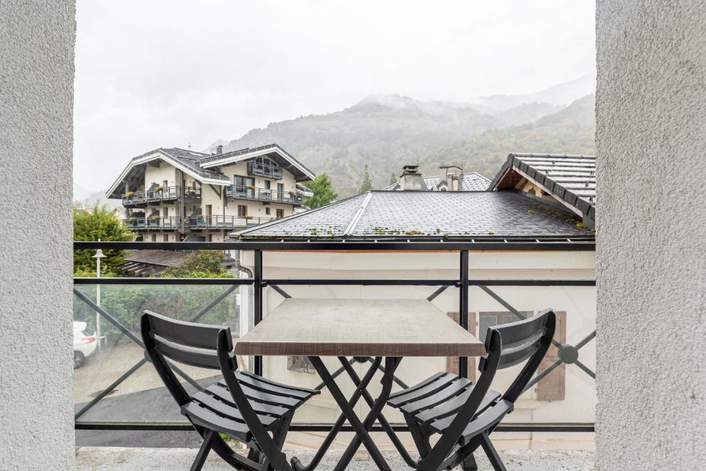 une table et des chaises sur un balcon avec vue dans l'établissement Appt Alba 6 pers plein centre, à Brides-les-Bains